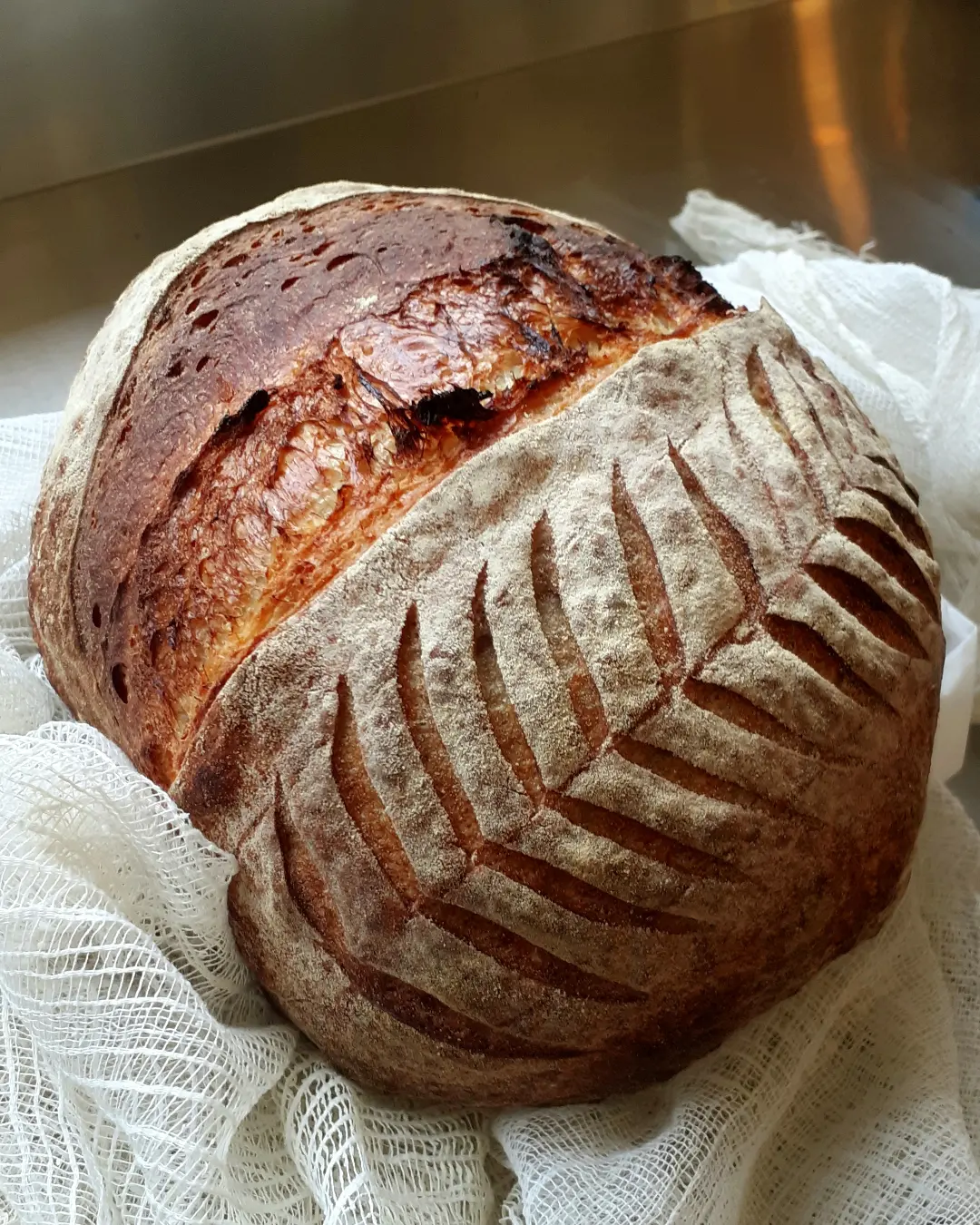 Fresh sourdough loaf wrapped in white cloth